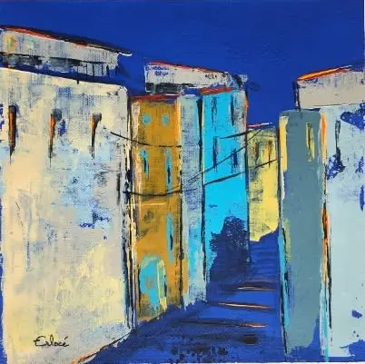 Calade (21) — Une ruelle bordée de hautes maisons ocre et turquoise sous un ciel bleu outremer, traversée de fils noirs.